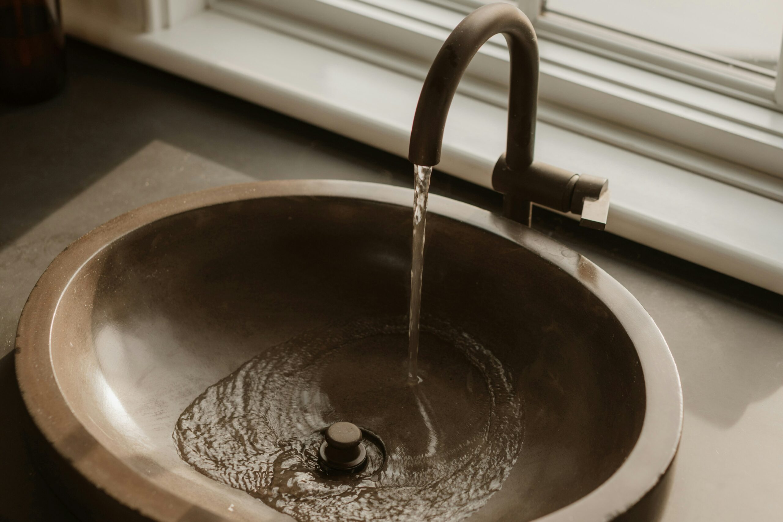 Wasser läuft aus einem Wasserhahn im Badezimmer